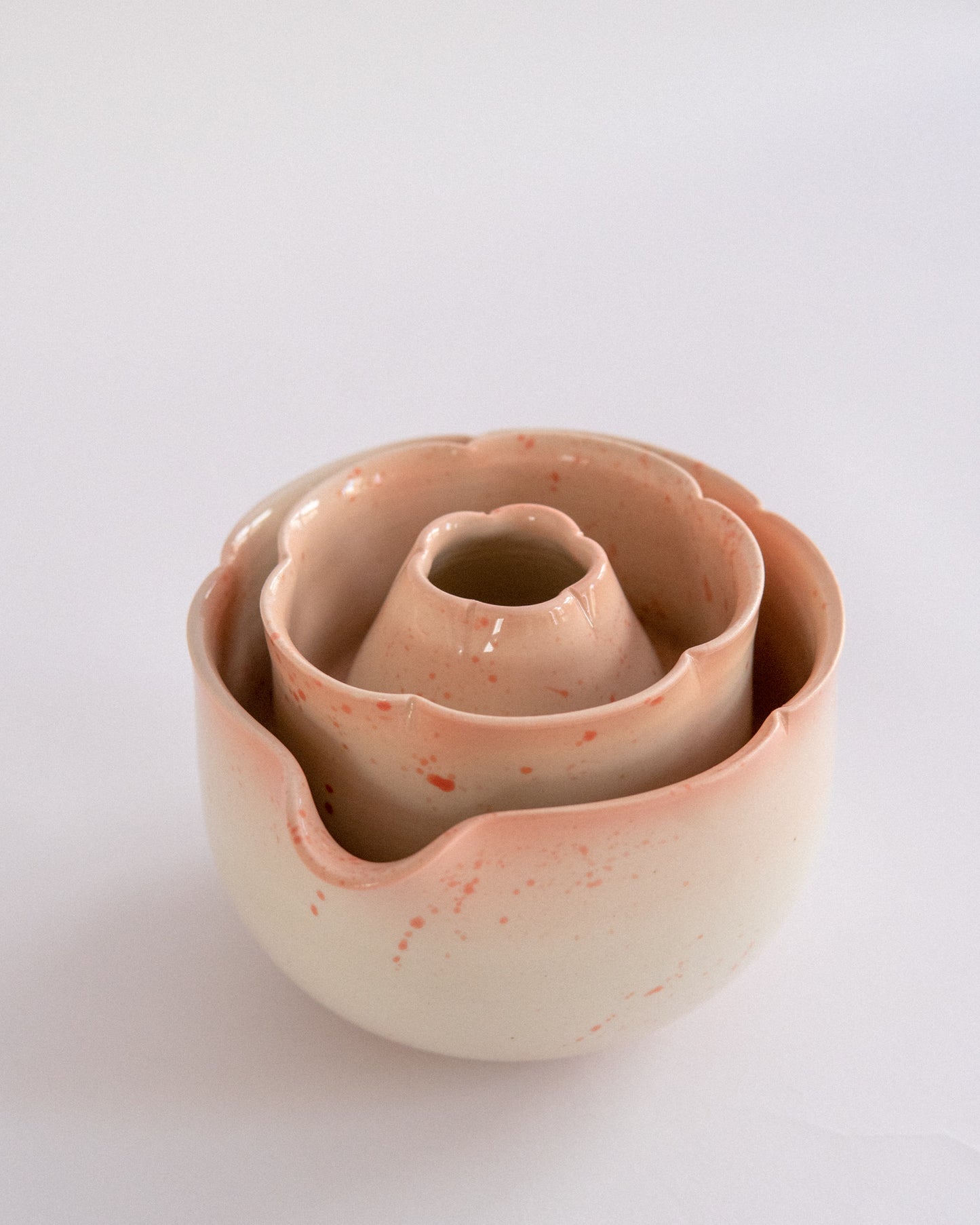 Set of three sakura-colored ceramic bowls stacked on a light gray background
